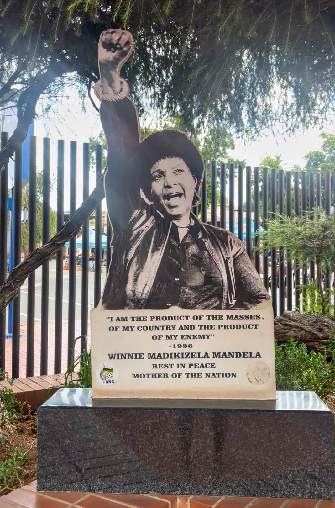 Outdoor monument to Winnie Madikizela-Mandela with raised fist, quote plaque, and Mother of the Nation tribute text