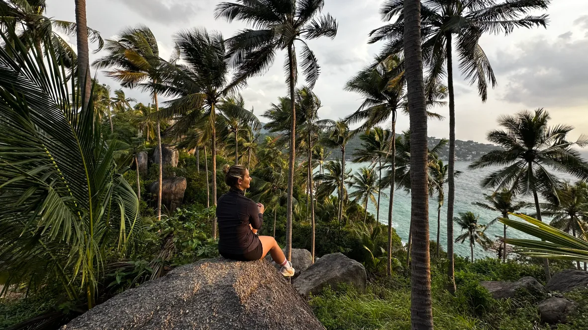 Leonie on a clifftop above palm trees and the ocean, Koh Tao