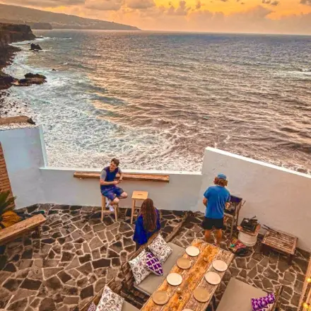 Stone terrace at a cliffside Azores coliving space at sunset overlooking the Atlantic