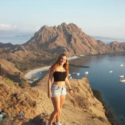 Leonie on a coastal overlook above a tropical bay