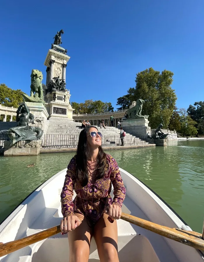 Salina Owens rowing on the Retiro Park lake in Madrid, with the Alfonso XII monument behind her