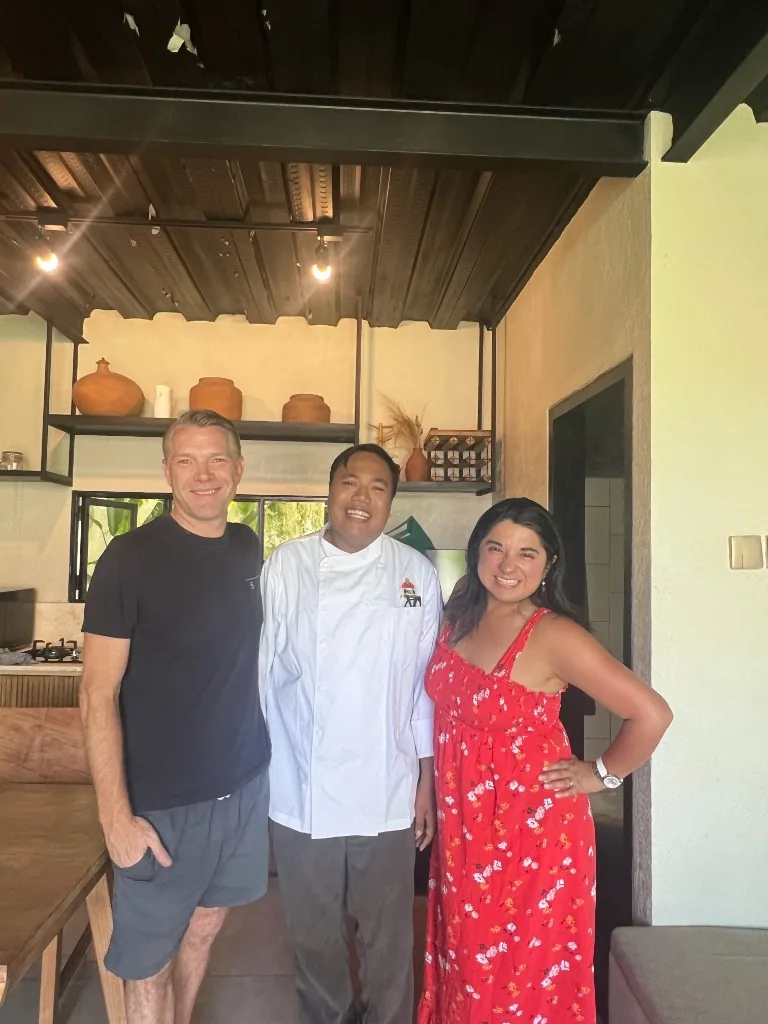 Nicole and her husband with a personal chef in a modern kitchen in Bali
