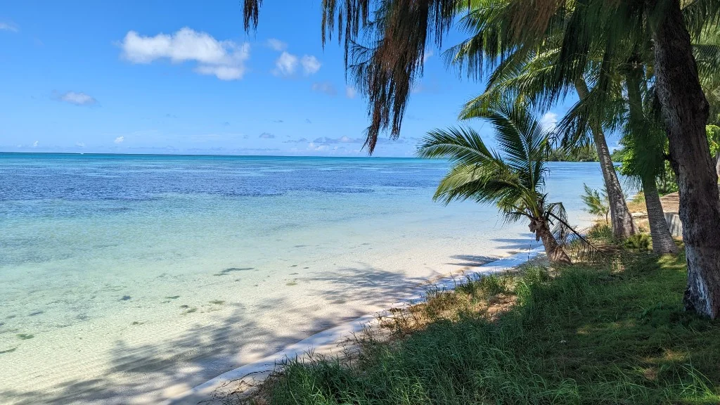 Turquoise water and white sand along Beach Road walkway, Saipan